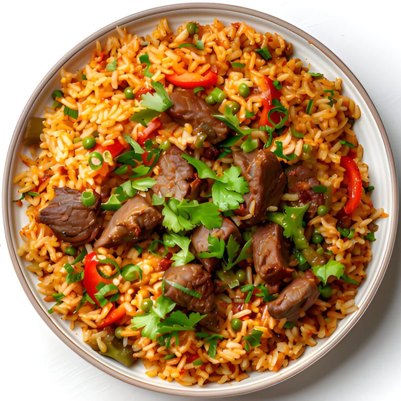Vietnamese fried rice with beef, red peppers, green peas, and fresh cilantro on a white plate.